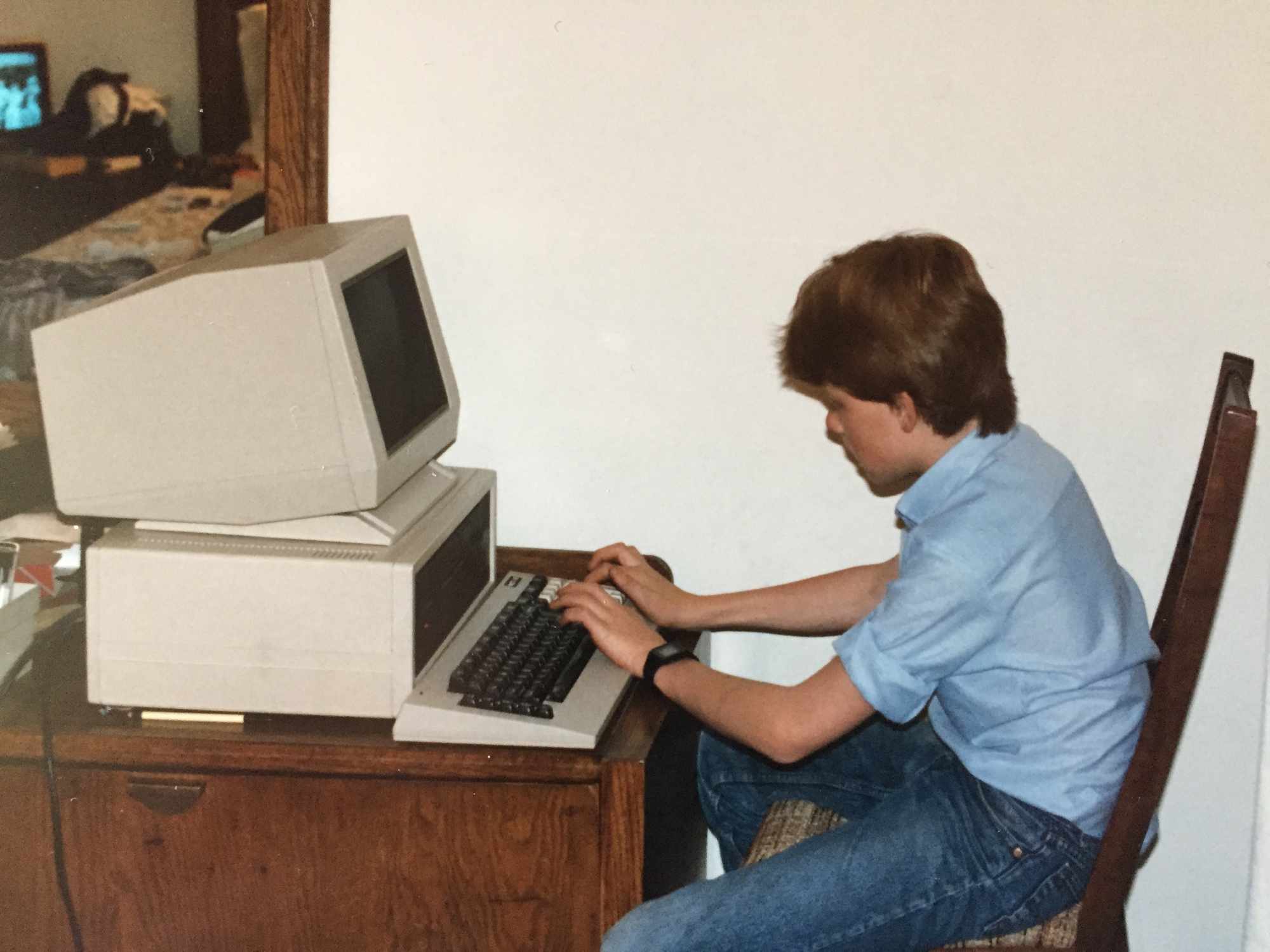 Tim as a young boy typing at a 1980s vintage computer